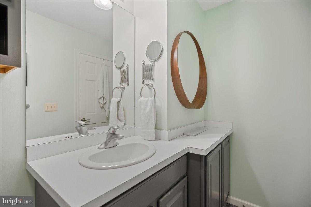 219 Calvert Drive Lusby, MD 20657 - Photo 32 of 51 a bathroom with a sink and a mirror