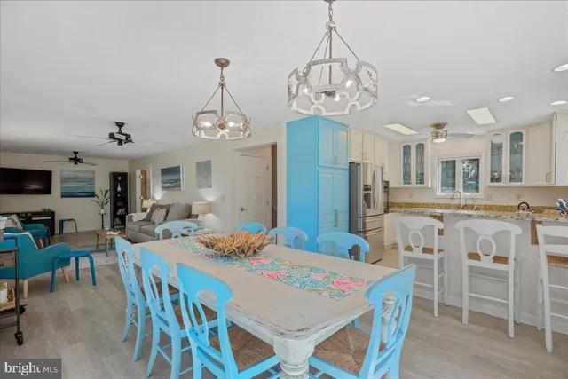 a view of a dining room with furniture a chandelier and wooden floor