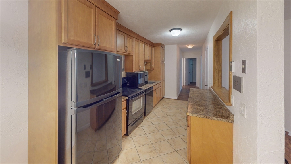 a kitchen with stainless steel appliances granite countertop a refrigerator and a stove
