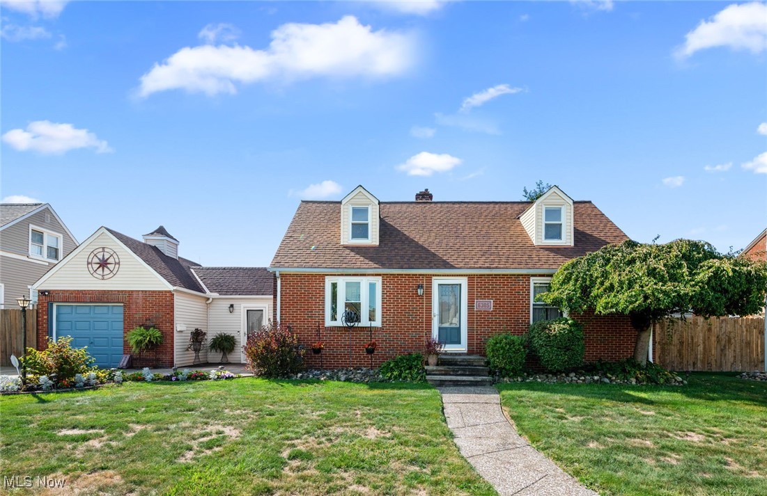 Cape cod house featuring a garage and a front lawn