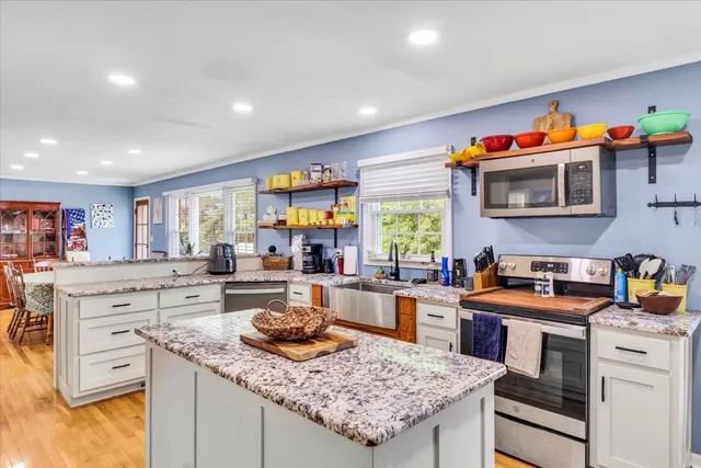 a kitchen that has a lot of cabinets in it and wooden floor