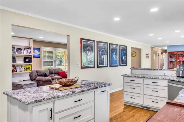 a kitchen with granite countertop a sink and a wooden floor