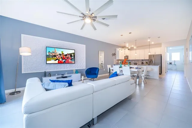 a living room with furniture and a view of kitchen