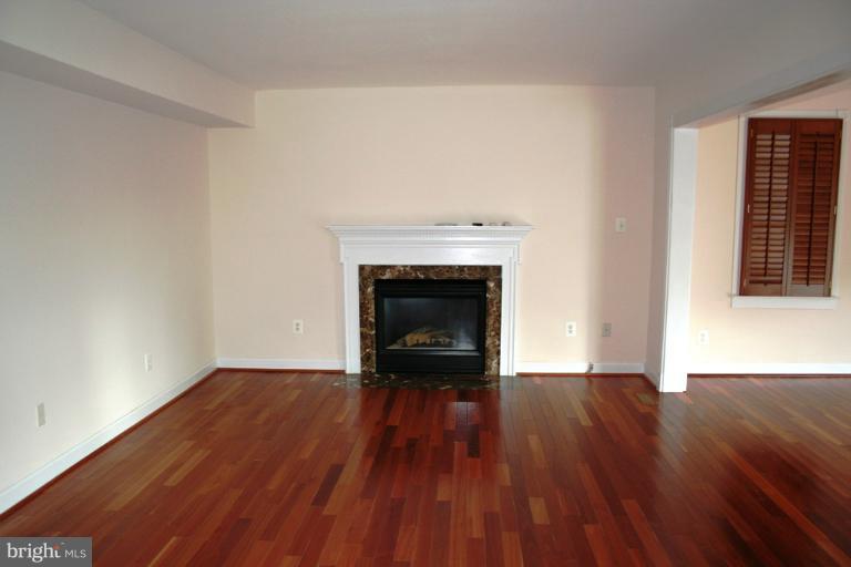 9303 Sandra Park Road Perry Hall, MD 21128 - Photo 7 of 25 an empty room with wooden floor and a fireplace