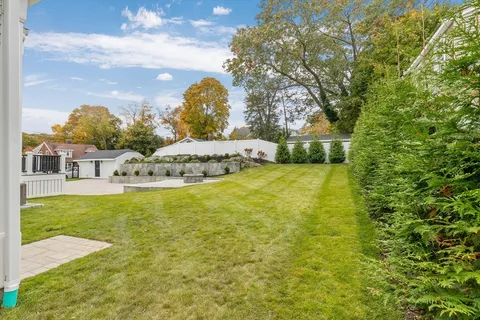 a view of a house with a big yard and large trees