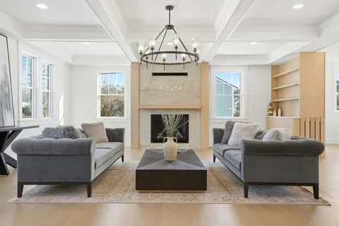 a living room with furniture a large window and a fireplace
