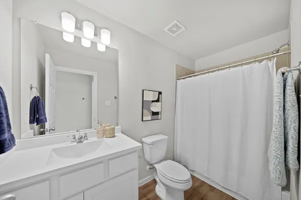 a bathroom with a sink vanity mirror and toilet