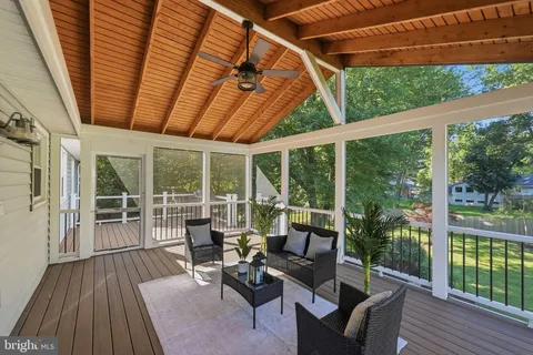 a balcony with wooden floor and outdoor seating