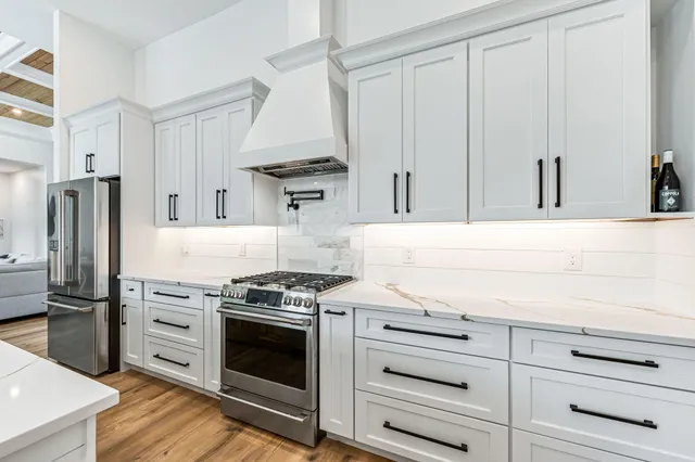 a kitchen with white cabinets and stainless steel appliances