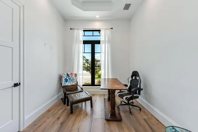 a view of a workspace with furniture and a window