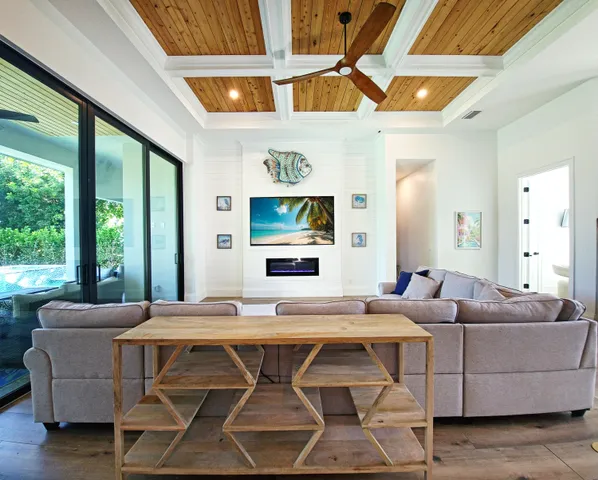 a living room with furniture a flat screen tv and a large window