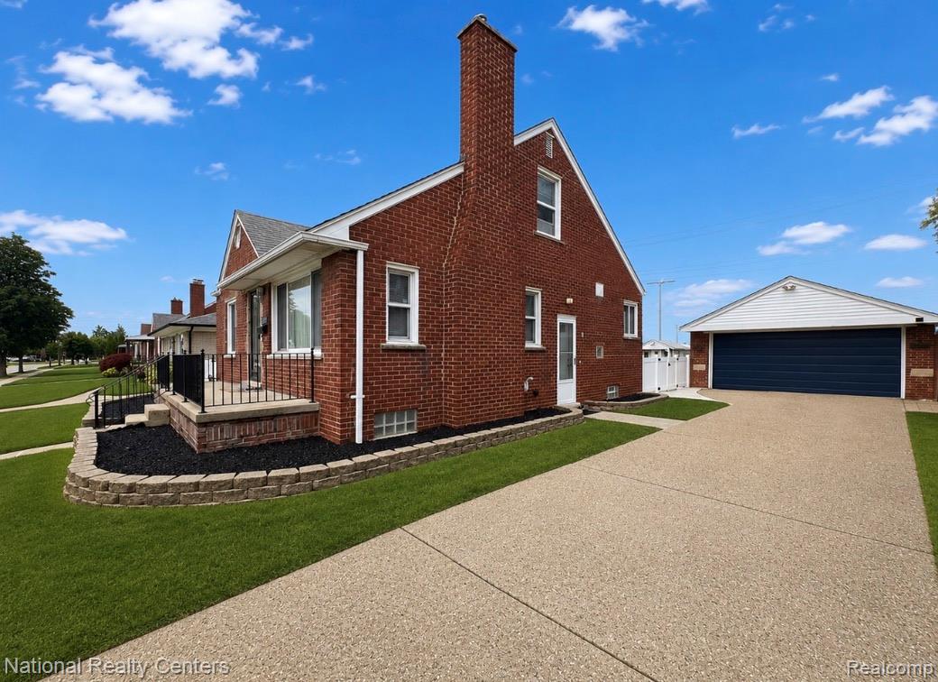 7285 Helen Street Center Line, MI 48015 - Photo 3 of 32 Brick exterior featuring a covered front porch with wrought iron railing, a detached garage with a dark blue door, and a concrete driveway