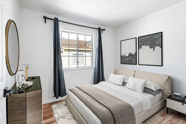 a bedroom with a bed a mirror and a window