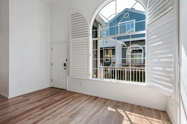 an empty room with wooden floor and windows