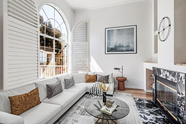 a living room with furniture a table and a large window