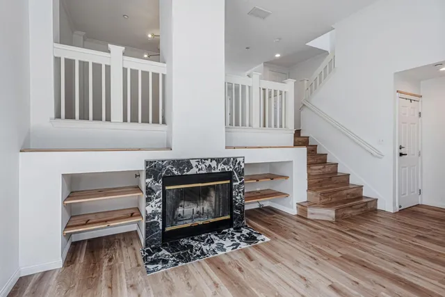 a living room with wooden floors and a fireplace