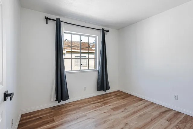 a view of a room with wooden floor and a window
