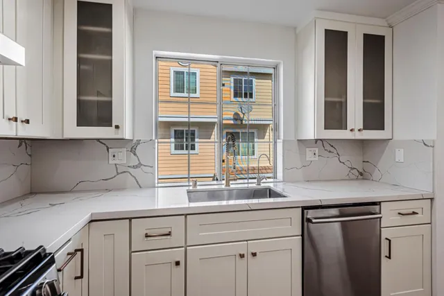 a kitchen with stainless steel appliances granite countertop white cabinets and a sink