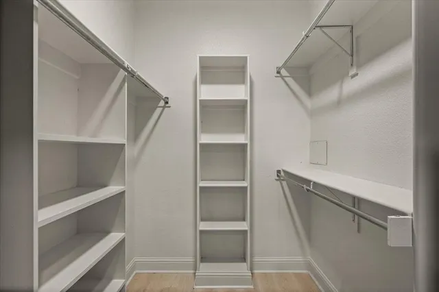 an empty room with windows and chandelier fan