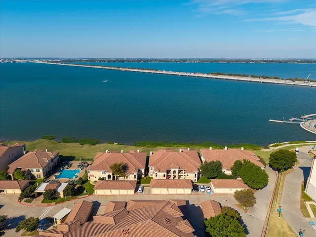 an aerial view of ocean and residential houses with outdoor space