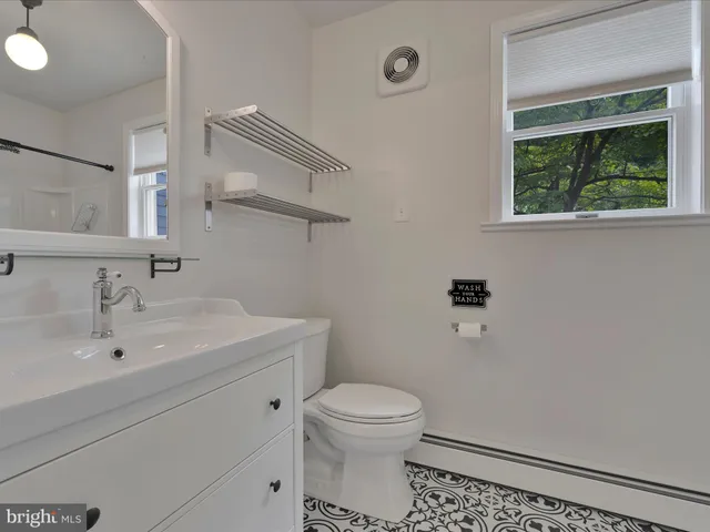 a bathroom with a toilet a sink and mirror