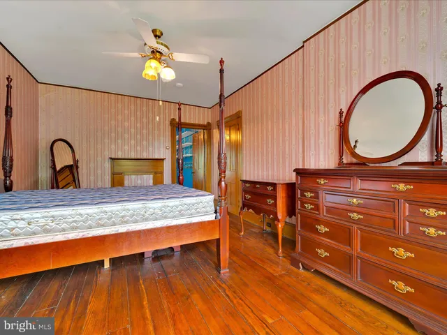 a bedroom with a bed and a dresser with mirror