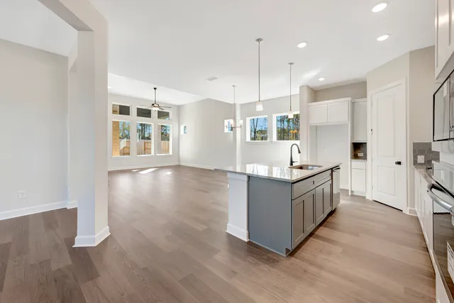 a kitchen with stainless steel appliances kitchen island wooden cabinets and a wooden floor