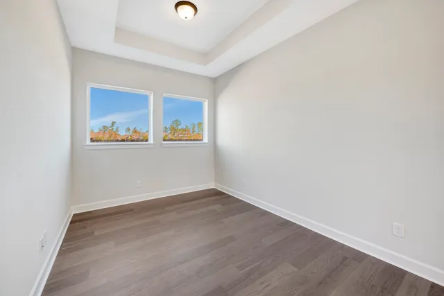 an empty room with a window and wooden floor