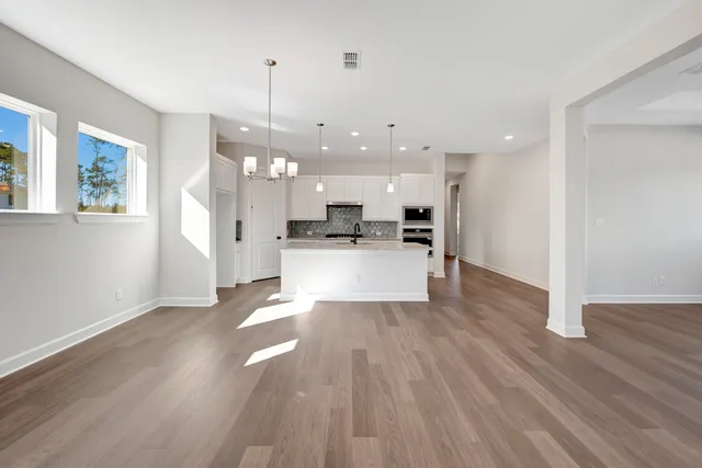 a view of a kitchen with wooden floor and a window