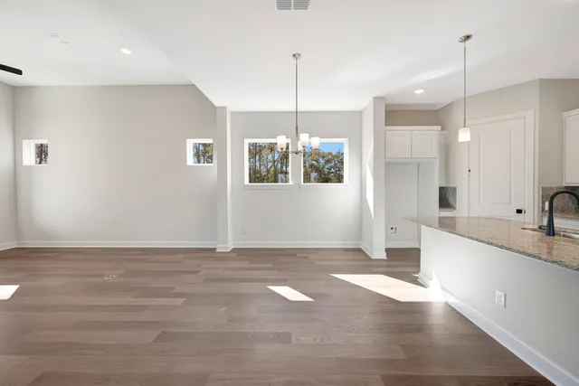 a view of a kitchen with a sink hardwood floor and a chandelier