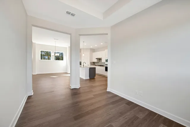 a view of a kitchen with wooden floor and a window