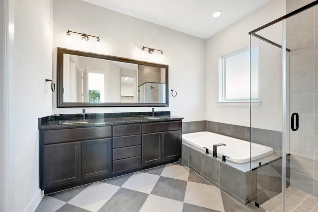 a bathroom with a tub sink and mirror