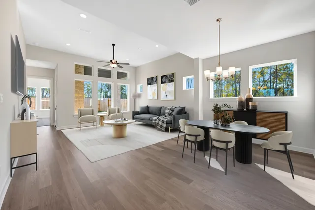 a view of a dining room and livingroom with furniture wooden floor a chandelier