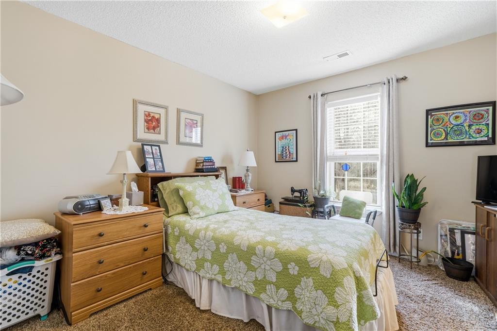 291 Buck Boulevard Southeast Calhoun, GA 30701 - Photo 11 of 32 a bedroom with a bed and a potted plant on the dresser