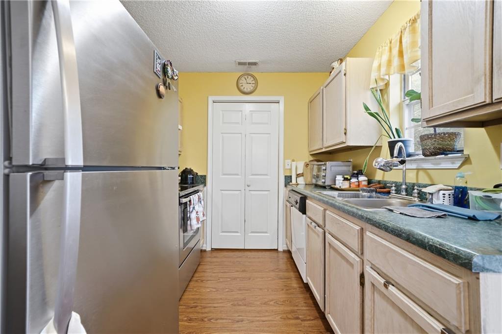 291 Buck Boulevard Southeast Calhoun, GA 30701 - Photo 22 of 32 a kitchen with a sink a refrigerator and cabinets