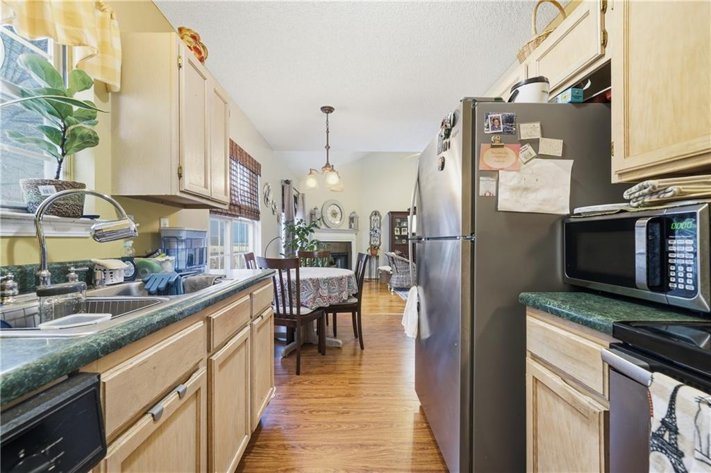 291 Buck Boulevard Southeast Calhoun, GA 30701 - Photo 24 of 32 a kitchen with stainless steel appliances granite countertop a refrigerator a sink dishwasher a stove and a dining table with wooden floor