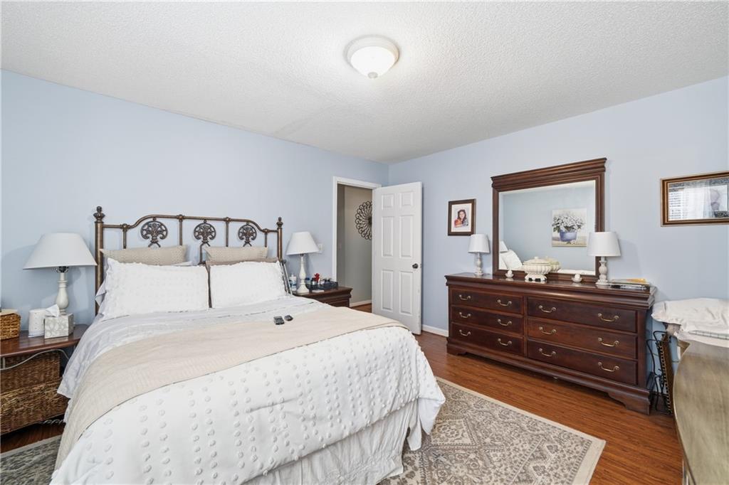 291 Buck Boulevard Southeast Calhoun, GA 30701 - Photo 8 of 32 a bedroom with a bed and dresser with mirror