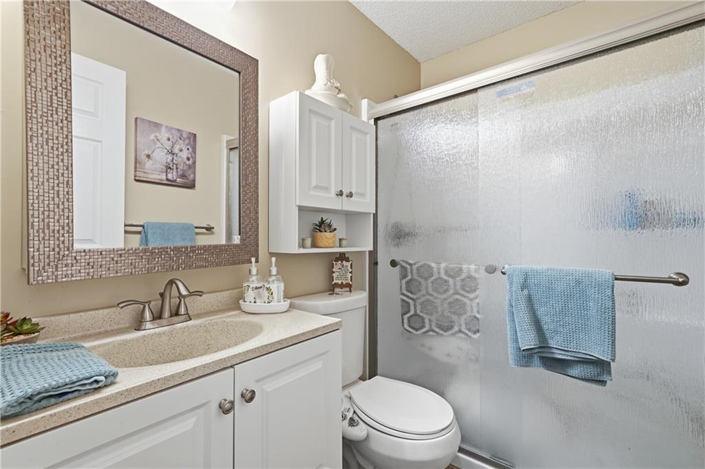 291 Buck Boulevard Southeast Calhoun, GA 30701 - Photo 10 of 32 a bathroom with a granite countertop sink a toilet and shower