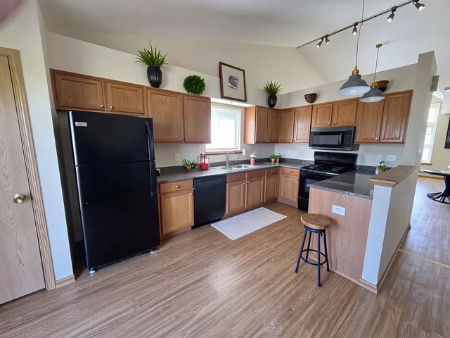 a kitchen with granite countertop a refrigerator stove top oven and sink