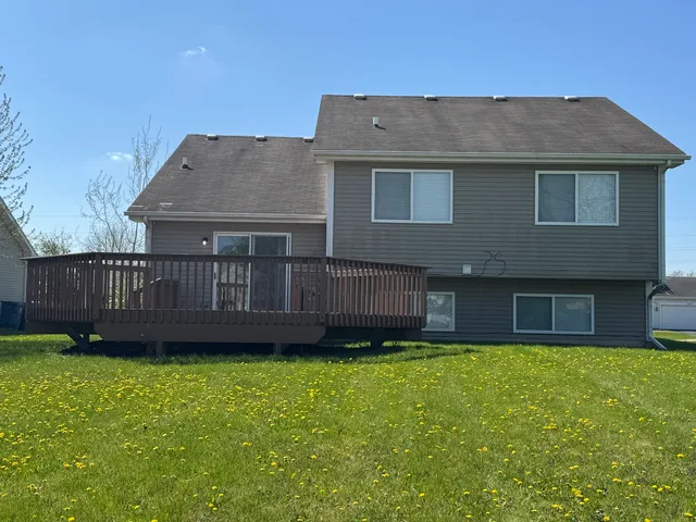 a view of a house with a yard and a wooden deck