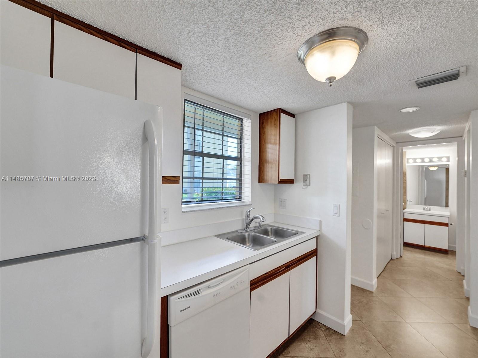 6339 La Costa Drive, Unit C Boca Raton, FL 33433 - Photo 12 of 23 a kitchen with stainless steel appliances granite countertop a sink a refrigerator and a granite counter tops