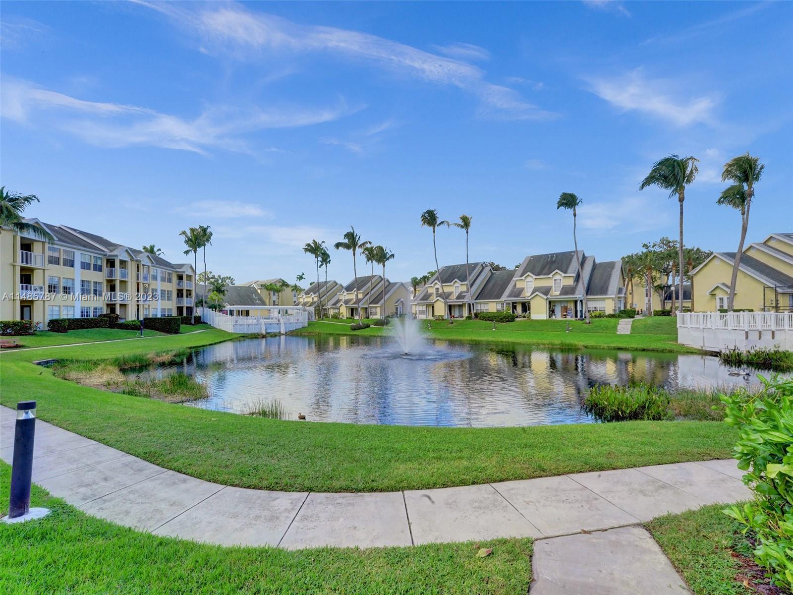 6339 La Costa Drive, Unit C Boca Raton, FL 33433 - Photo 10 of 23 a front view of a house with a garden and lake