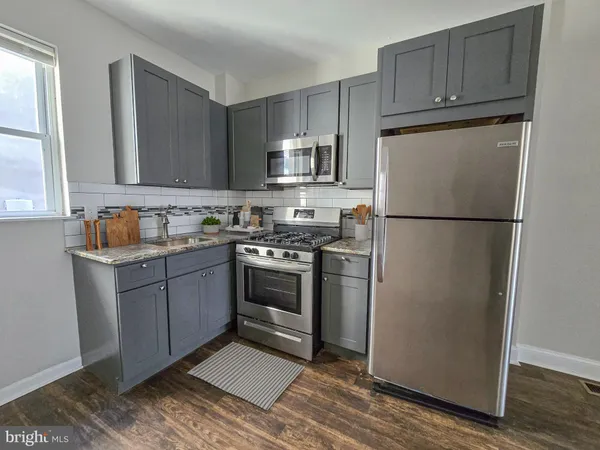 a kitchen with a refrigerator sink and cabinets