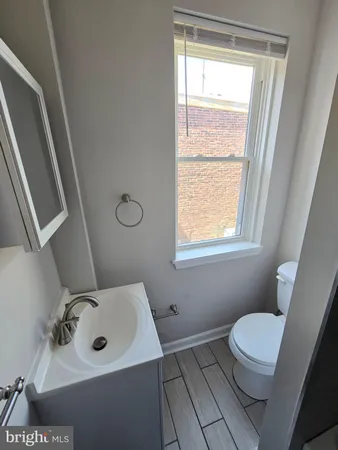 a bathroom with a sink a toilet and a window