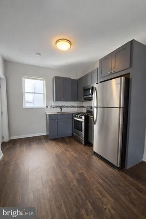 a kitchen with wooden floors and stainless steel appliances