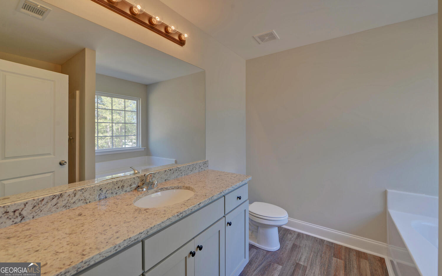 2994 Cannon Bridge Road Demorest, GA 30535 - Photo 14 of 36 a bathroom with a granite countertop sink a toilet and a window