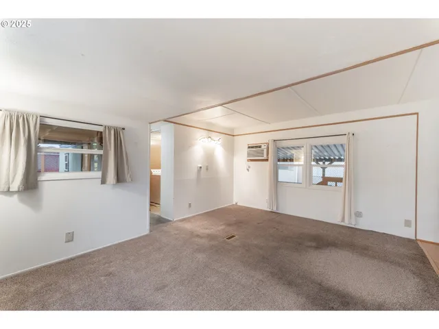 a view of a big room with wooden floor and windows