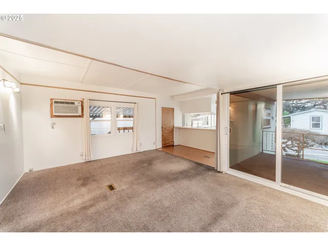 a view of a big room with wooden floor and windows