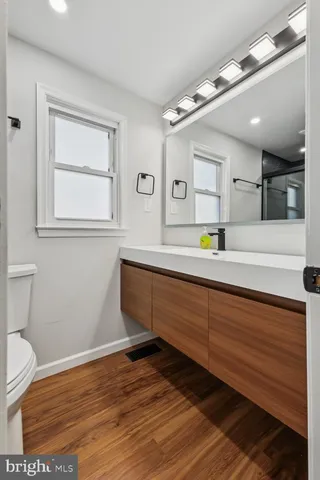 a bathroom with a sink mirror vanity and toilet