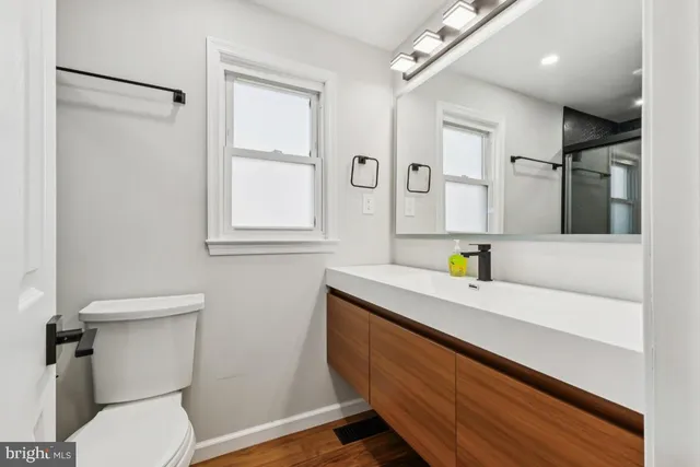 a bathroom with a sink a toilet and a mirror